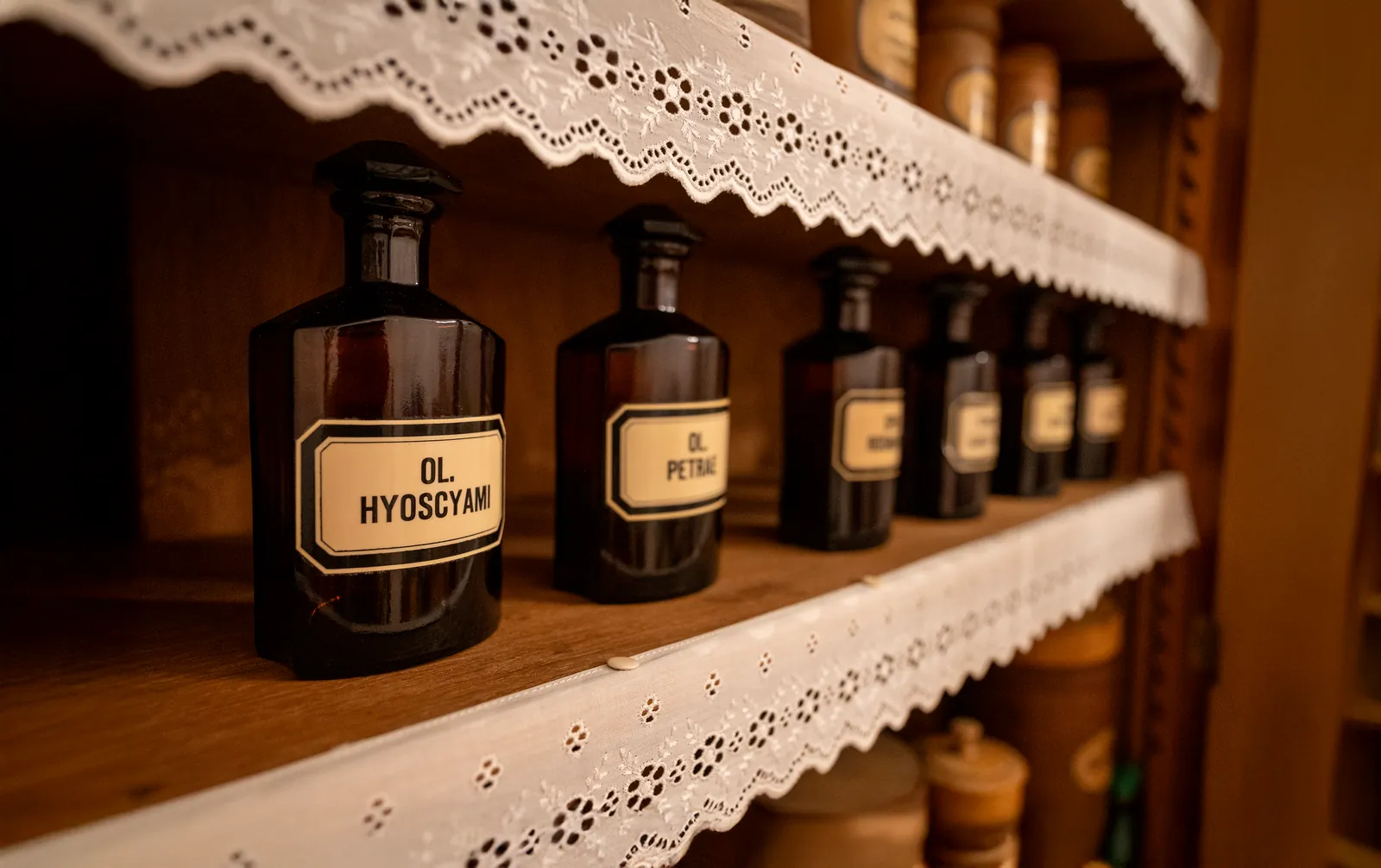 Historische Apothekerflaschen im Holzregal der Schutzengel Apotheke